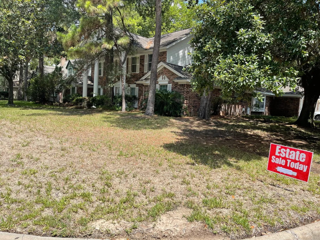 A yard with a red sign in front of it.