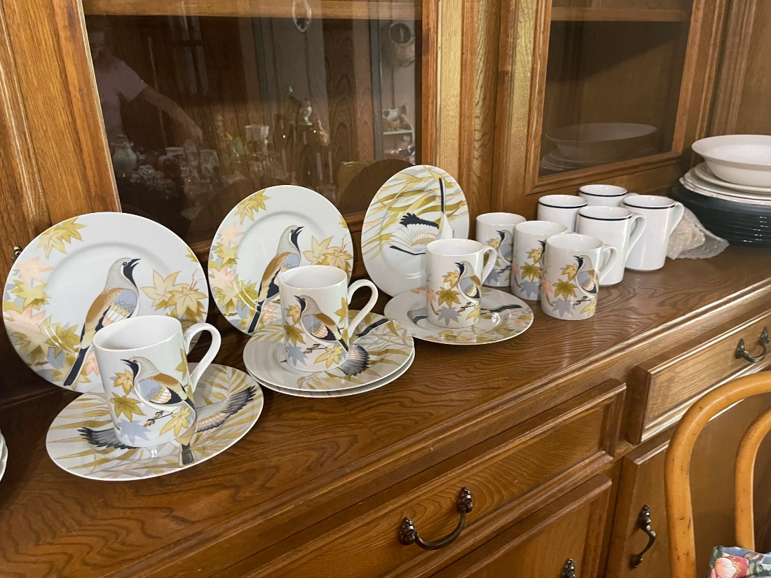 A display of cups and saucers on top of a wooden table.
